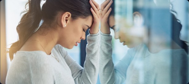 A woman holding her head and looking down